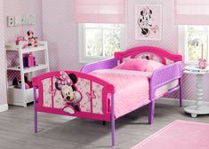 a child's bedroom with minnie mouse bedding and pink carpeted flooring