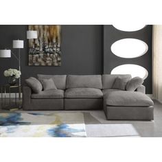 a living room with a sectional couch and large round mirrors on the wall above it