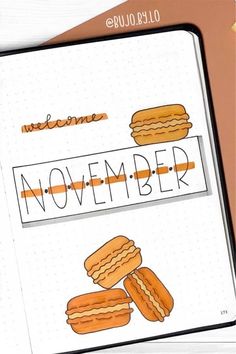 an open notebook with the words november written on it and some cookies in front of it