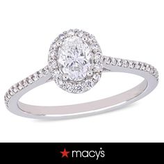 a white gold ring with an oval diamond center and pave set diamonds around the band