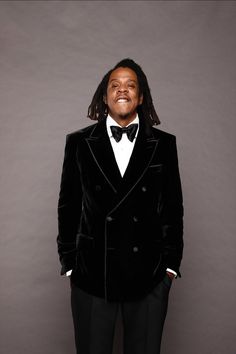 a man in a tuxedo poses for a photo