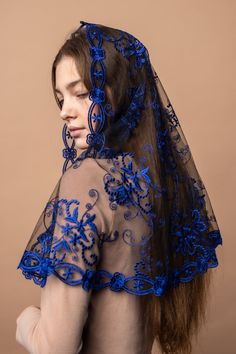 a woman wearing a veil with blue flowers on the side and long hair in the back