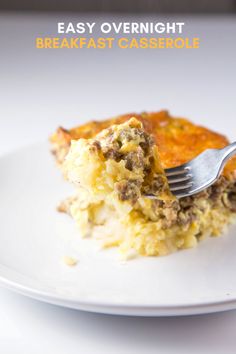 a white plate topped with a slice of casserole covered in meat and cheese