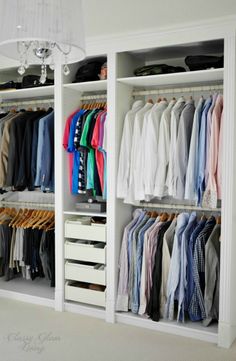 an organized closet with clothes hanging on the shelves and white drawers, all in different colors