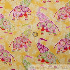 an elephant pattern on yellow fabric with pink and green accents