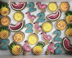 decorated cookies in the shape of numbers with fruits and flamingos on them are displayed