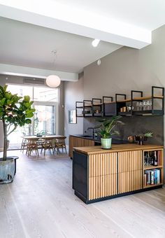 an instagram photo of a living room and dining area with shelves on the wall