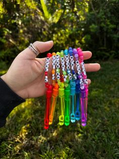 a person holding six different colored pens in their hand with the letters o on them