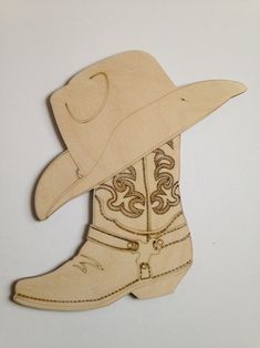 a wooden cutout of a cowboy's boot and hat on a white background