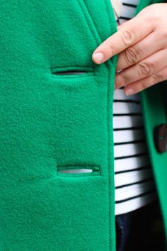 a close up of a person wearing a green coat