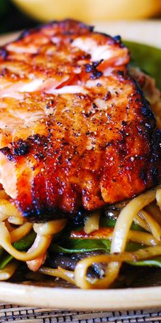 a close up of a plate of food with meat and noodles on it's side