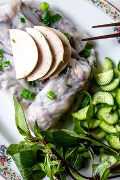 an assortment of food on a plate with cucumbers