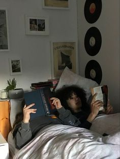 a woman laying in bed reading a book