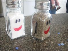 two salt and pepper shakers sitting on top of a counter next to each other