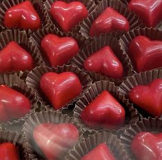 there are many heart shaped chocolates in the tray together, and one is red