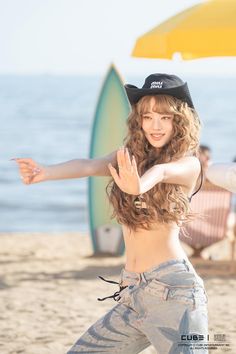 a young woman is dancing on the beach with her arms stretched out to the side