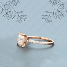 an engagement ring with a large peach colored diamond in the center and small white diamonds around it