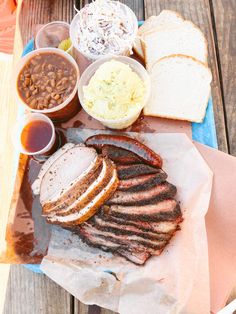 a platter with meat, beans and cole slaw