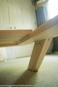 a wooden bench sitting on top of a carpeted floor