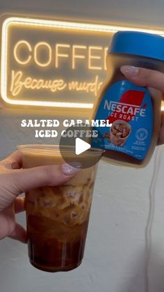 someone is holding up a cup of coffee with whipped caramel and ice cream on it