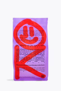 a red and purple sticker with a smiley face on it's side, in front of a white background