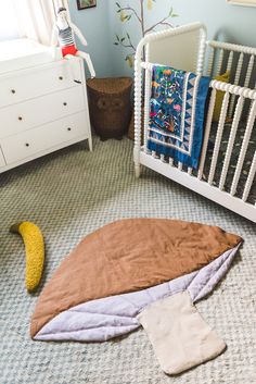 a baby's room with a crib, bedding and toys on the floor