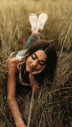 a woman laying in the grass with her eyes closed