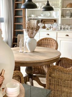 a dining room table with wicker chairs