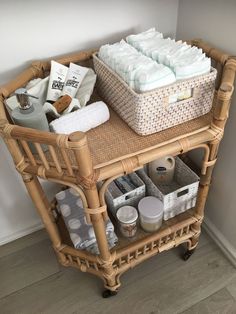 a wicker cart filled with lots of items on top of a hard wood floor