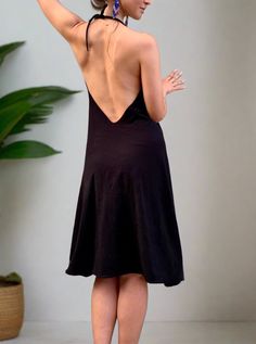 Simple black flowing dress. If we were to transform our favorite pair of black glorkapants into the dress - this would be it! Simple stretchy black dress that fits most sizes, and has two adjustable straps (you can tighten them up behind the neck and pull them lower if you want a deeper opening, or higher if you want more of the sporty look). This dress is a perfect everyday wear, as well as a cute going-out outfit. We danced in it, we meditated, did sun salutations and sat for a sound bath. We played with the belt, wrapping it around in different ways each time creating a different look! We love it! Try it out and play with it! Material: Cotton jersey (90% cotton 10 lycra). Very smooth and breathable. The dress is being handmade in two of our studios in New York and Los Angeles. Size: One Black Stretch Suspender Dress For Spring, Stretch Halter Neck Slip Dress For Night Out, Black V-neck Suspender Dress For Night Out, Chic Black Backless Suspender Dress, Black Dress With Spaghetti Straps And Built-in Bra, Black Spaghetti Strap Dress With Built-in Bra, Stretch Halter Neck Slip Dress, Black Low-back Slip Dress For Evening, Black Low Back Slip Dress For Evening