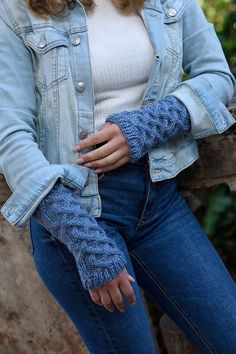 a woman wearing a denim jacket and gloves