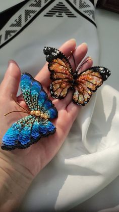 two butterflies that are sitting on someone's hand