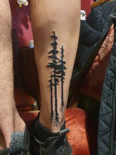 a man's leg with trees on it