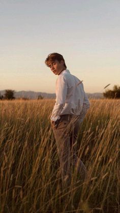 a man standing in the middle of tall grass