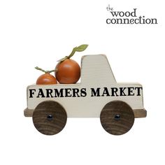 a wooden toy truck with tomatoes on the back and words farmers market painted on it