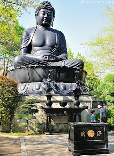 a large buddha statue sitting in the middle of a park