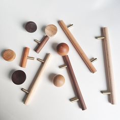 several wooden pegs and knobs on a white surface with one turned upside down