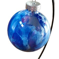 a blue glass ornament hanging from a wire