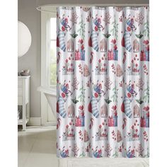 the shower curtain is decorated with colorful flowers and houses on white fabric, along with a bathtub