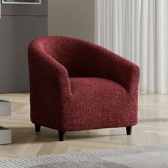 a red chair sitting on top of a hard wood floor next to a white rug