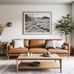 a living room with a couch, coffee table and potted plant in the corner