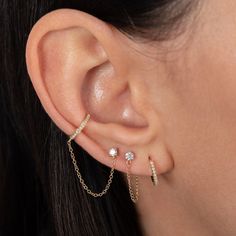 a close up of a person's ear with two piercings on it and one behind the ear