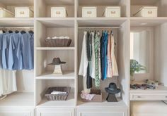 an organized closet with clothes, shoes and other items on shelves next to a desk