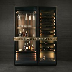 an open wine cabinet with bottles and glasses in the door, lit up at night