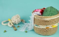 a basket filled with yarn next to a crochet hook and ball of yarn