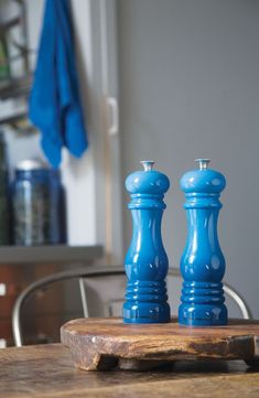 two blue salt and pepper shakers sitting on top of a wooden table