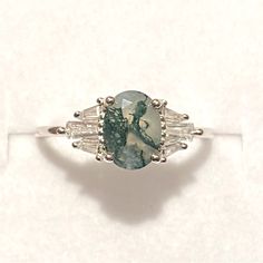 a ring with a green and white stone in it