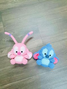 two crocheted stuffed animals sitting on top of a wooden floor