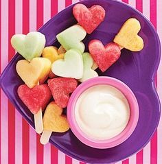 valentine's fruit kabobs with yogurt and hearts on a purple plate