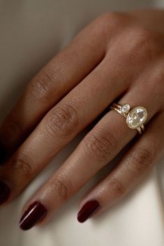 a woman's hand with a ring on it and a diamond in the middle